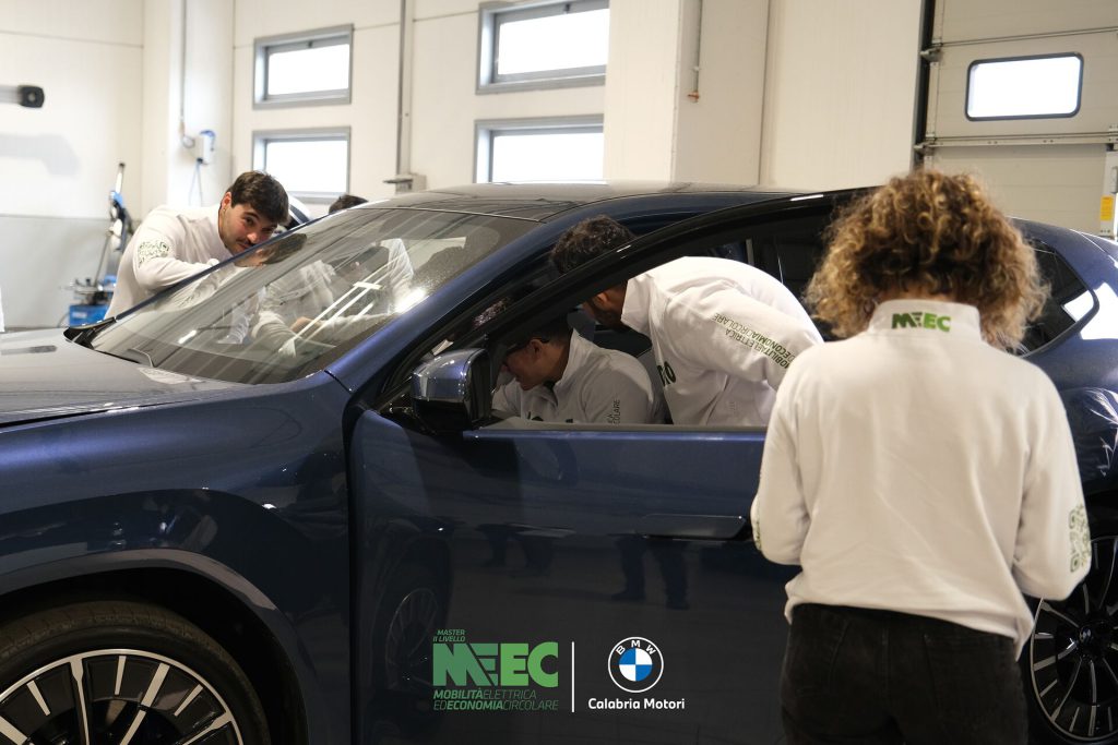 Corsisti del Master MEEC attorno a una BMW elettrica in officina durante il corso executive sulla manutenzione del veicolo elettrico