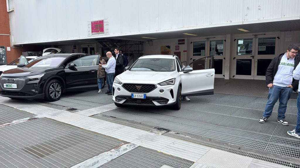 Corsisti del Master MEEC accanto a una vettura elettrica durante le prove su strada