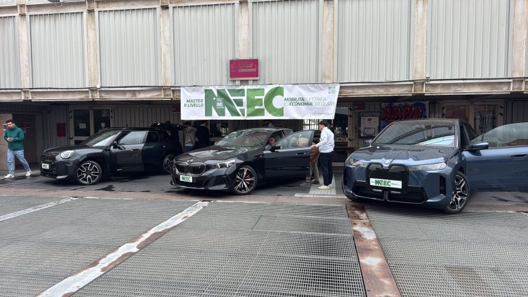 Auto elettriche schierate davanti allo striscione MEEC per le prove su strada del modulo powertrain