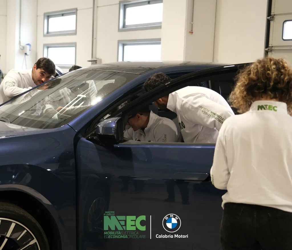 Corsisti del Master MEEC osservano l’abitacolo di un’auto elettrica in officina